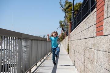 Fototapeta na wymiar Break free. Energetic child run on promenade. Happy boy enjoy free time. Having fun. Summer vacation