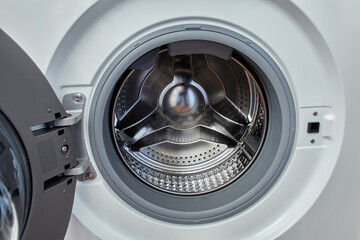 Washing machine with open door and empty drum.