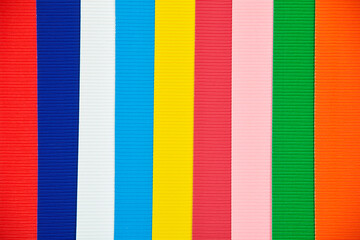 Multicolored vertical stripes of corrugated paper or cardboard.