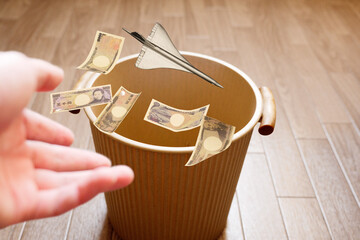 高コストの超音速旅客機を手放すイメージでお金と共にゴミ箱に投げ捨てる
