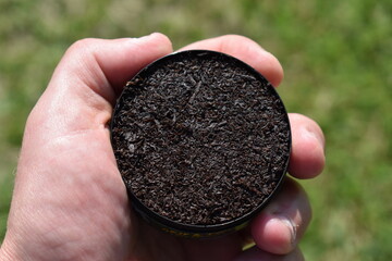 Can of Chewing Tobacco Held in a Hand