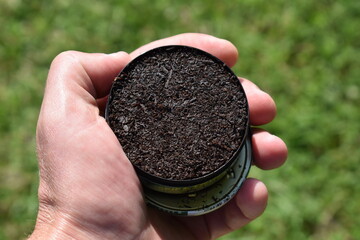 Can of Chewing Tobacco Held in a Hand - obrazy, fototapety, plakaty