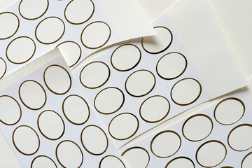 gold tipped ovals - highlighting their negative space - fixed to textured paper - variously arranged on old paper - photographed from above in a flat lay style - with ambient light