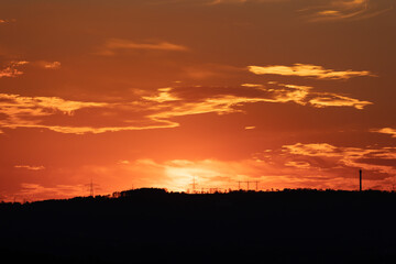 silhouette of high voltage power lines and pylons against a beautiful sunset - beautiful clouds on the sunset sky
