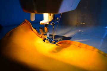 Fototapeta na wymiar Maquina de coser con tela color amarillo