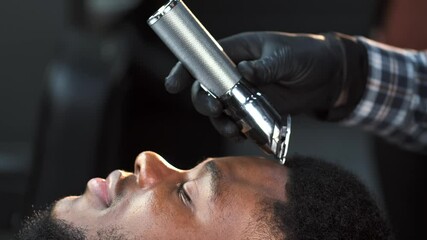 Male barber shaving client haircut in barbershop