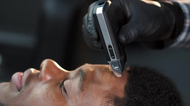 Male barber shaving client haircut in barbershop