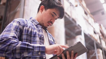 slow motion scene middle eastern auditor man use digital tablet to check order in storage at  distribution warehouse cargo for manage about delivery of import and export concept