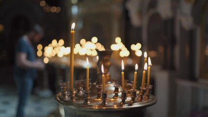 The theme of religion, faith, Christianity, God and the Orthodox Church. A close-up of much waxed candles are burning in a candlestick in the Volodymyrsky Cathedral in Kiev. Religious concept