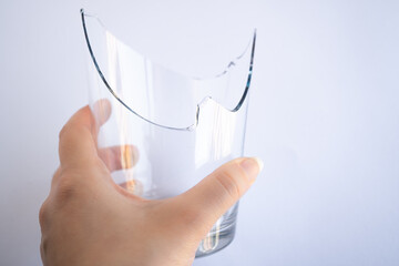 vaso de vidrio transparente roto con mano