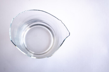 mitad de vaso de vidrio transparente roto con fondo blanco