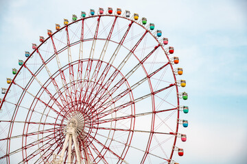 Ferris wheel on cloudy sky background taken from Odaiba, teleport station Tokyo Japan.