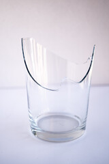mitad de vaso de vidrio transparente roto con fondo blanco
