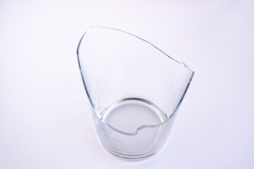 mitad de vaso de vidrio transparente roto con fondo blanco