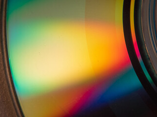 Abstract photo of the reflection of the bottom of a CD displaying a wide array of colors on its...