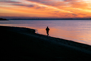 Fototapeta premium silhouette of a person on the beach at sunset