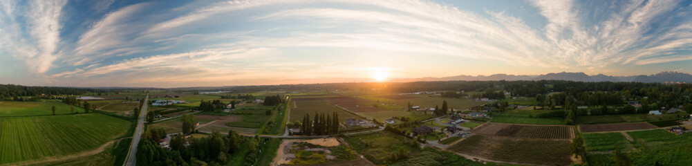 Aerial Panoramic View of Farm Fields in Fraser Valley during colorful Sunset. Taken in Langley, Greater Vancouver, British Columbia, Canada.