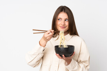 Teenager caucasian girl isolated on white background holding a bowl of noodles with chopsticks