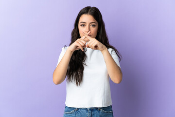 Young caucasian woman isolated on purple background showing a sign of silence gesture