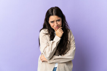 Young caucasian woman isolated on purple background having doubts