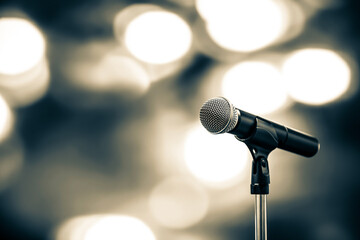 Fototapeta na wymiar Microphone Public speaking backgrounds, Close-up the microphone on stand for speaker speech presentation stage performance with blur and bokeh light background.