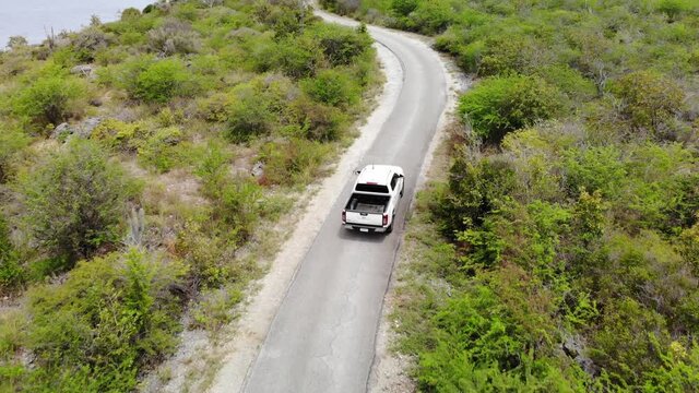 Pickup truck driving on the tropical island of Bonaire, part of the Caribbean Netherlands.
