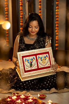 Portrait Of An Indian Woman Holding A Gift Box On The Festive Occasion Of Diwali. Celebrations At Home.