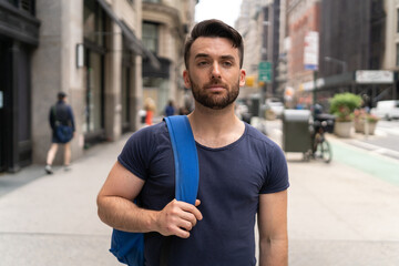 Young caucasian man on city street walking serious face