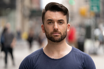 Young caucasian man on city street serious face portrait