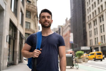 Young caucasian man on city street walking smile happy face