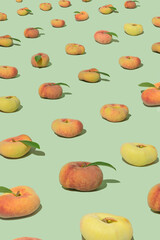 Fresh organic donut peaches pattern in perspective on green background.