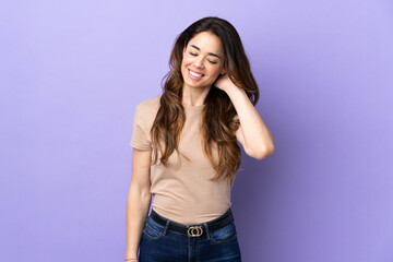 Woman over isolated purple background laughing