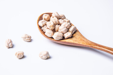 a spoon of dried chickpeas against white background