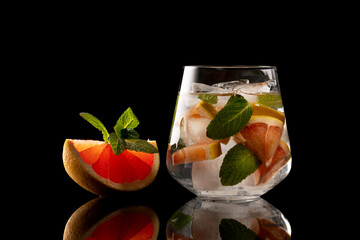 orange and mint slice and glass with orange and mint ice drink isolated on black background