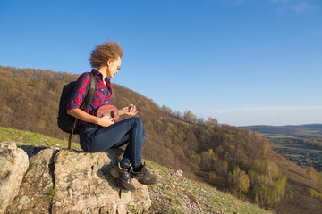 Naklejka na ściany i meble Woman with guitar ukulele in the mountains, amazing landscape, stunningly beautiful nature, mountains, sunset Hiking in the mountains