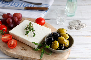 Greek feta cheese on a black plate. Greek authentic feta cheese with olives on the side.