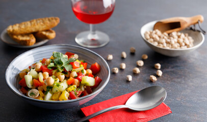 Homemade chickpea salad. Homemade healthy vegan salad, with chickpea , tomato, cucumber, paprika served in a bowl. Healthy meal, on a dinner table.