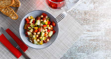 Homemade chickpea salad. Homemade healthy vegan salad, with chickpea , tomato, cucumber, paprika served in a bowl. Healthy meal, on a dinner table.