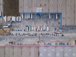 4k Aerial shot of trucks on warehouse parking terminal.