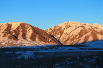 sunset mountain with snow and blue sky