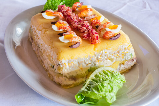 Causa Limena, a Typical Dish in Peruvian Cuisine Served with Onions, Crayfish and Quail Eggs