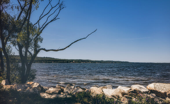 Strand am Zarnowitzer See in Lubkowo am Jezioro Żarnowieckie im Sommer bei wolkenlosem Himmel. Bucht und Ufer im Sommer am Sandstrand in Polen.