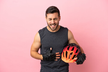 Young cyclist man isolated on pink background smiling a lot - obrazy, fototapety, plakaty