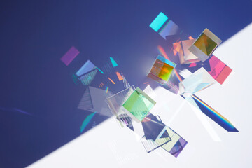 Abstract background with glass geometric figures prisms with light diffraction of spectrum colors...