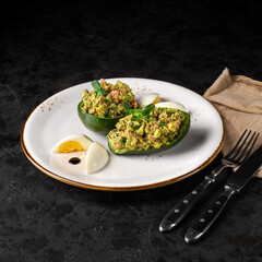 Salad with tuna, avocado, tomatos, coriander and lemon juice served in avocado bowls