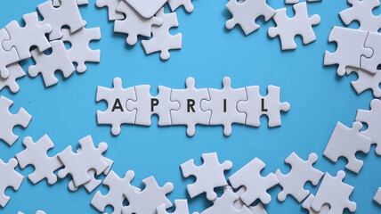 APRIL word written on white jigsaw puzzle