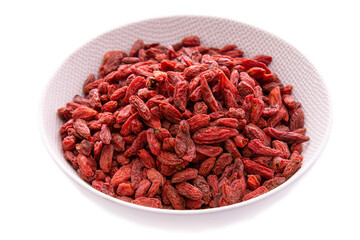 Dried goji berries in a light plate on a white background.isolated products