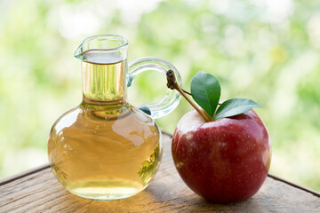 Apple fruit and Apple Cider Vinegar on nature background.