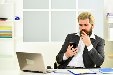 Multitasking. confident brutal businessman. Elegant businessman analyzing data in smartphone....