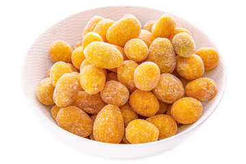 kumquats fruit in sugar in a light plate on a white background.